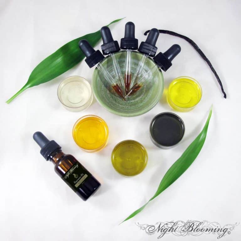 Signature Oil Blends bottle with droppers in a green bowl and small dishes of oils